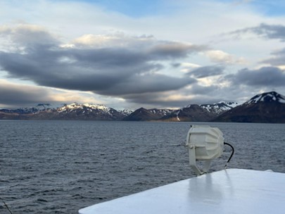 View from a ship across water to snow peaked mountains