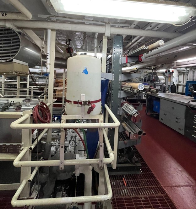 A room full of pipes, railings, tubes, and tanks