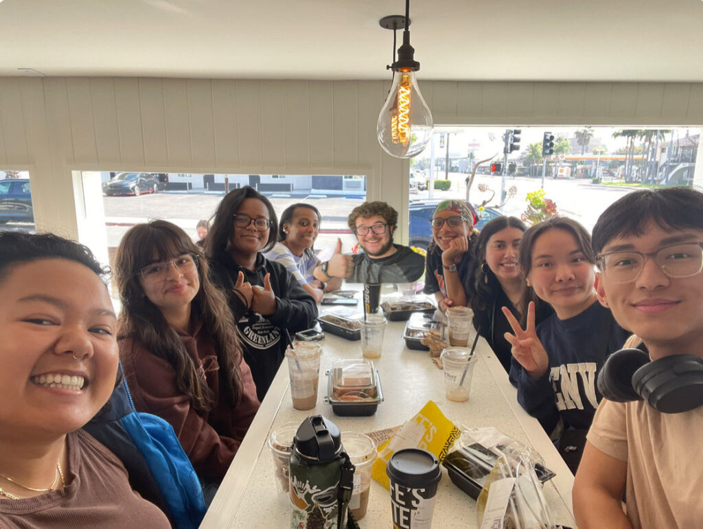 A group of students gathers around a table for breakfast