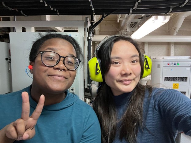Two scientists pose with ear protecting headphones and ear plugs