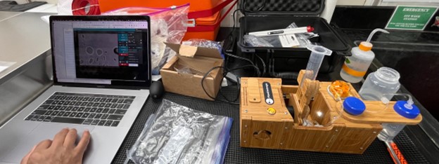 A laptop and a wooden box with a test tube