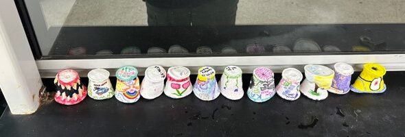 A row of decorated, shrunken styrofoam cups