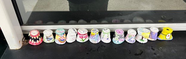 A row of decorated, shrunken styrofoam cups