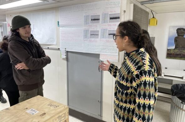 A student points at a scientific poster