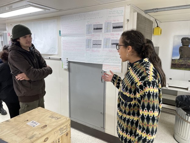 A student points at a scientific poster