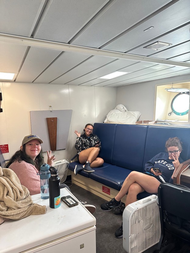 researchers sitting on couches in the ship conference room 