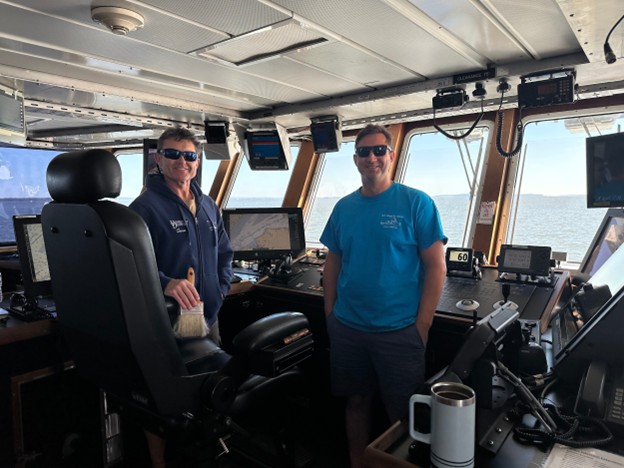 ship captains standing with the steering equipment in the bridge 