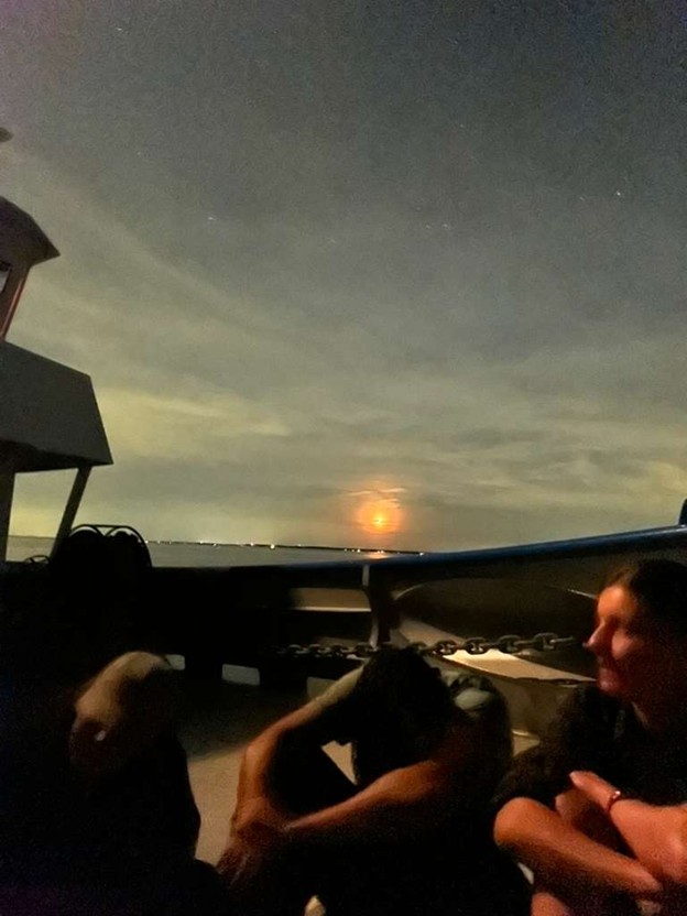students on the bow of the ship at night